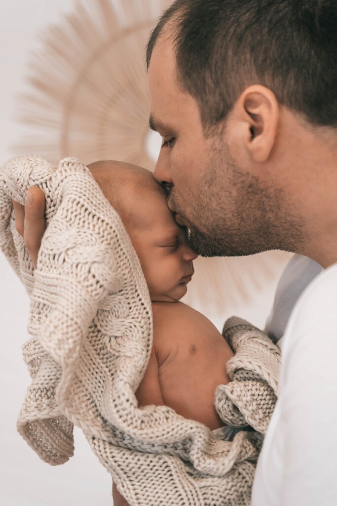 Papa und sein kleiner Sohn in Liebe anhand der Babyfotografie für immer festgehalten