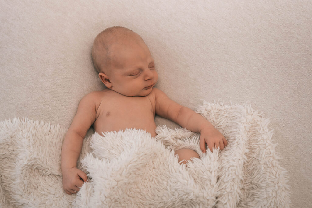 Neugeborenenbilder von einem kleinen Jungen im Fotostudio