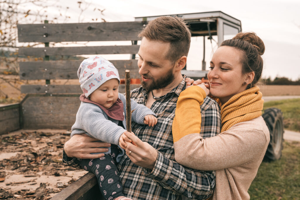 Mama, Papa und die kleine Tochter bei einem Fotoshooting mit der Familie in der Natur nahe Offenburg durch einen Familienfotografen