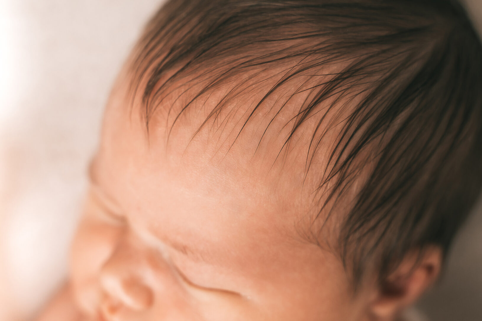Detailaufnahmen der Haare des Mädchens bei einer Fotosession mit einem Neugeborenen