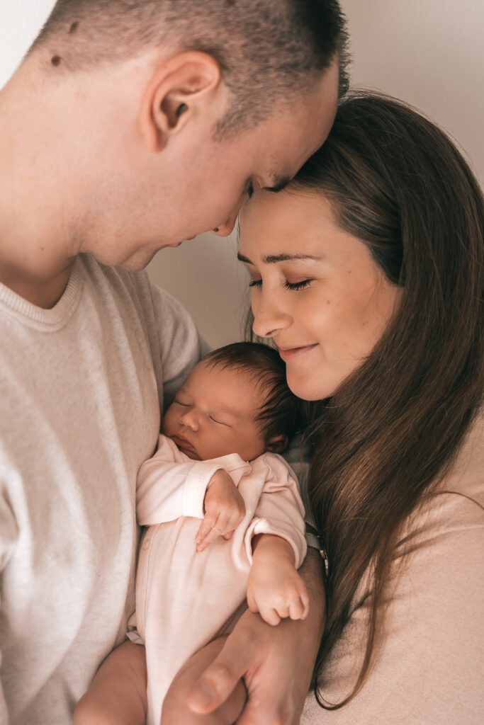 Ein emotionales Bild von den Eltern mit ihrem Baby bei einem Fotoshooting in Bad Säckingen - Selina Denz, deine Fotografin für liebevolle und natürliche Babyshootings in Lörrach und Rheinfelden - Newbornfotografin Selina Denz